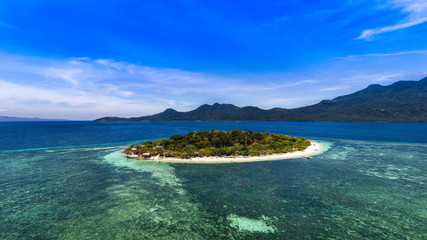 White sand beaches on Mantigue Island with the Volcanic Camiguin Island in the background.