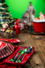 Christmas time. Christmas tableware and decorations. Red and brown colors. Rustic wooden background.