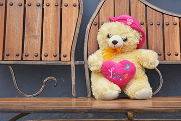 Teddy bear sitting on a wooden chair