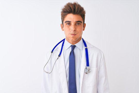 Young handsome doctor man wearing stethoscope over isolated white background puffing cheeks with funny face. Mouth inflated with air, crazy expression.