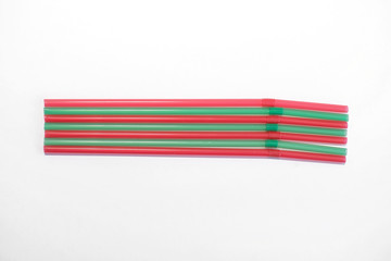 red and green cocktail straws on a white background for design and decoration