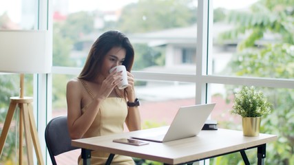 Young beautiful woman working with laptop at coffee shop