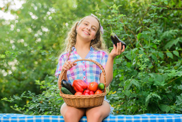 Eco farming. Girl cute smiling child living healthy life. Healthy lifestyle. Eat healthy. Summer harvest concept. Gmo free. Healthy homegrown food concept. Kid gathering vegetables nature background