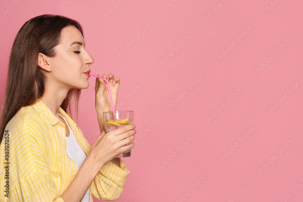 Sticker young woman drinking lemon water on pink background. space for text