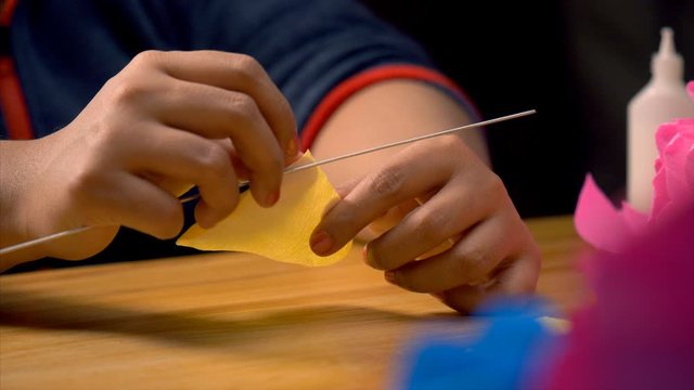 A clip of paper craft where a flower petal is being crafted. Free Stock Video - A yellow paper is being crafted into a beautiful petal of the rose flower by rolling its edges