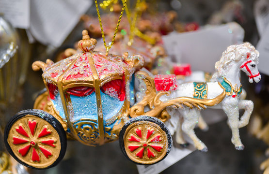 Christmas tree toys in the form of a Royal carriage drawn by white horses, as from a fairy tale about Cinderella hang on sale in the store