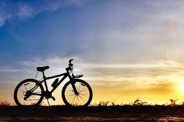 Fototapeta na wymiar silhouete bicycle with beautiful sunset or sunrise sky