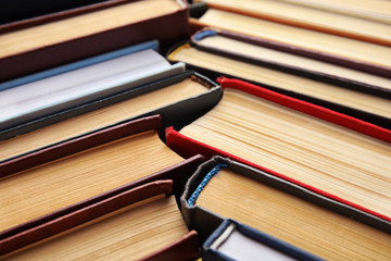 Many different hardcover books as background, closeup