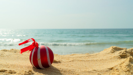 red christmas ball toy on the beach against the sea new Year