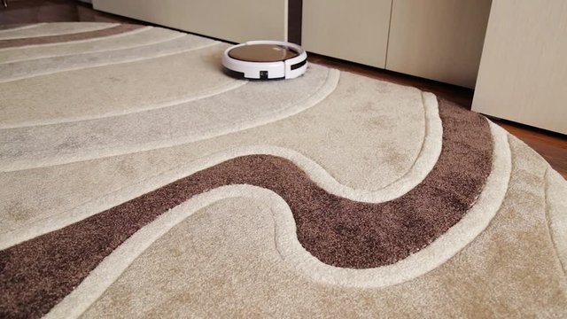 Robot vacuum cleaner cleans the floor from dust. Smart house.