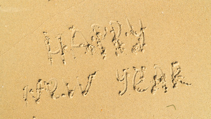 Lettering Happy New Year on the beach sand Lettering Happy New Year on the beach sand