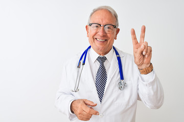 Senior grey-haired doctor man wearing stethoscope standing over isolated white background smiling looking to the camera showing fingers doing victory sign. Number two.