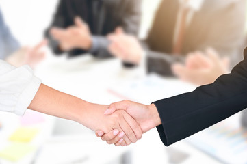 Fototapeta na wymiar Businesswoman shaking hands with colleague or partner in modern office.