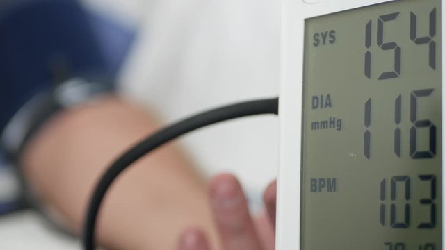 Image with Man in Hospital Checking His Blood Pressure