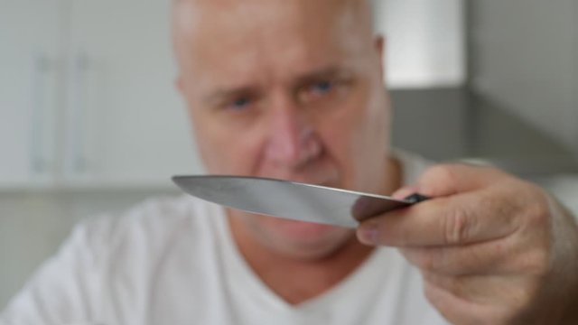 Man Check and Make Sharp a Big Knife Used in the Kitchen