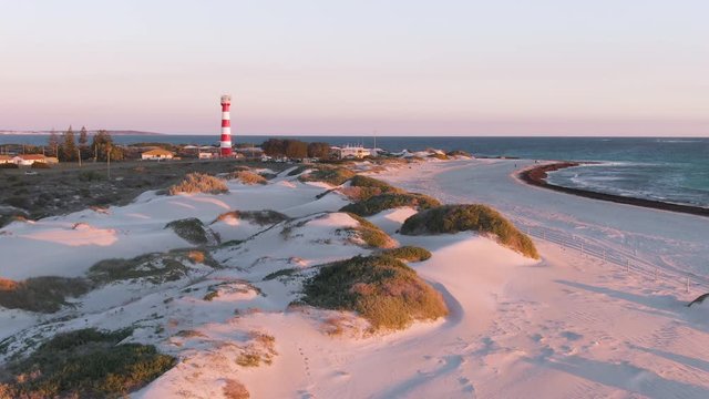 Aerial: Gorgeous sunset footage of Geraldton beach on west end and lighthouse in the background. Western Australia.