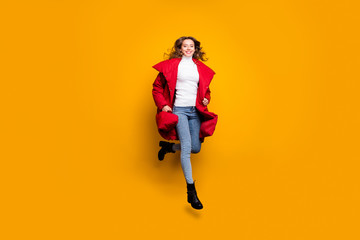 Fototapeta na wymiar Full body photo of amazing lady jumping high walking street sale shopping wear jeans shoes white pullover red long winter coat isolated yellow color background