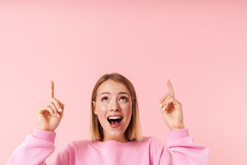 Portrait of alluring woman smiling and pointing fingers upward