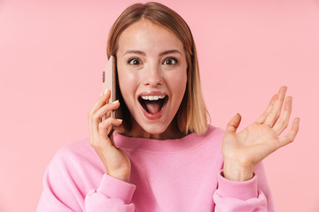 Portrait of optimistic blonde woman smiling and talking on smartphone
