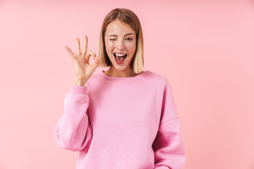 Portrait of beautiful woman smiling and showing ok sign with fingers