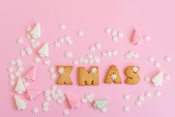 cookies letters Xmas on pink background. creative Christmas concept.
