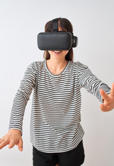 Young beautiful chinese woman playing virtual reality game using goggles