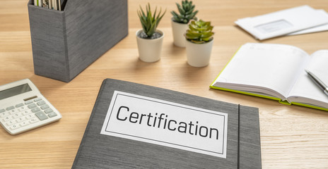 A folder on a desk with the label Certification