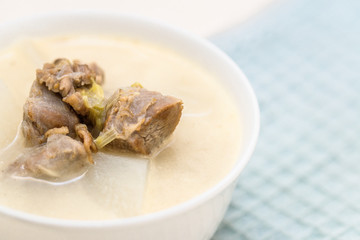 A bowl of mutton stew with radishes was set on the table