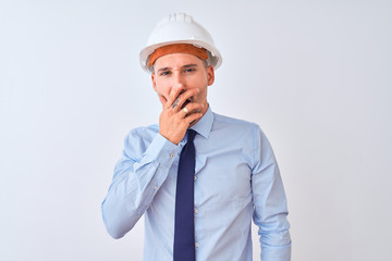 Young business man wearing contractor safety helmet over isolated background bored yawning tired covering mouth with hand. Restless and sleepiness.