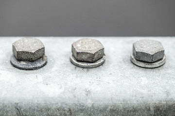 Three gray bolts in a row, close-up