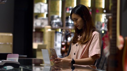 Young woman paying by scanning QR Code with smartphone