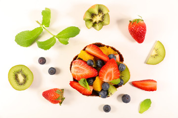 fruit salad with strawberry, blueberry, kiwi, orange and banana- top view on white background