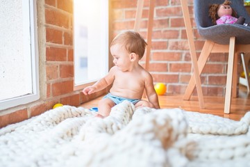 Beautiful toddler sitting on the blanket at kindergarten