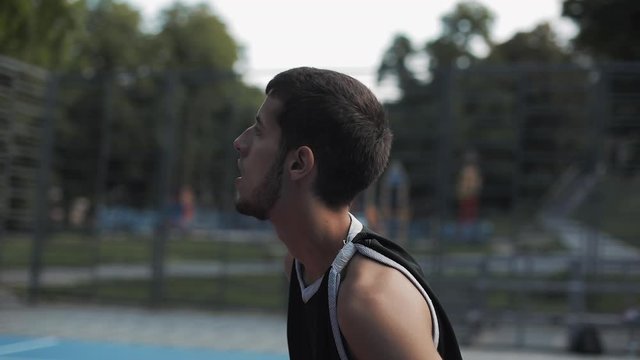 Young Bearded Caucasian Guy Throwing Succesfully Ball to Hoop Rejoicing Looking Happy and Satisfied at Street Basketbal Sports Field. Healthy Lifestyle and Sport Concept. 360 Video in Slow Motion.