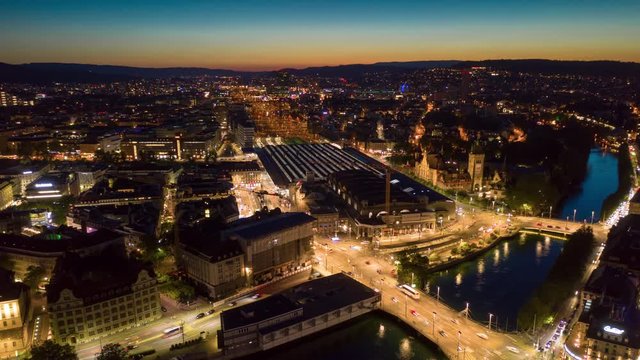sunset night illuminated zurich city traffic train station square aerial panorama 4k timelapse switzerland 