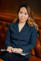 Beautiful young East Asian woman sitting in a cafe with a laptop