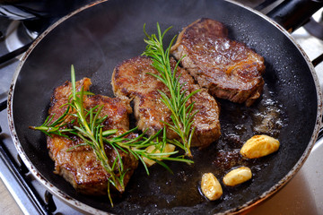 Grilled premium rib eye beef steak in the pan, cooking steak in the kitchen on a dark background, top view