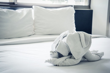 Fototapeta na wymiar Dog shaped towel on the bed