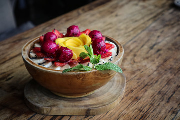 Smoothie bowl decorated with mango, strawberry, banana and dragon fruit