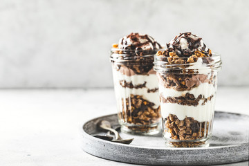 Yogurt parfait with granola, chocolate and ice cream. Sweet delicious breakfast - obrazy, fototapety, plakaty