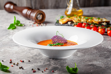 Italian food concept. Tomato soup with mussels and basil from farm vegetables. Modern serving in a restaurant. Background image. Copy space.