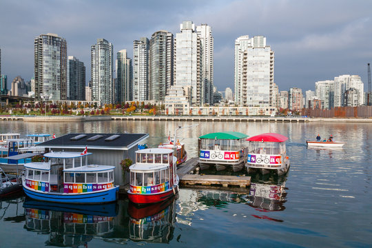 VANCOUVER, CANADA - OCTOBER 23, 2006 : Aquabus ferries moored at Granville Island with Downtown Vancouver in the background. The ferry transports commuters and tourists to destinations in False Creek.