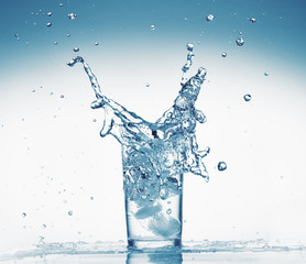 one glass of water with splash from falling ice cube, white background, isolated object
