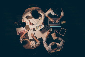 High angle above view photo of four business partners colleagues sitting table working together...