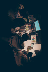 High angle above view vertical photo of four busy hard-working business people working overtime...