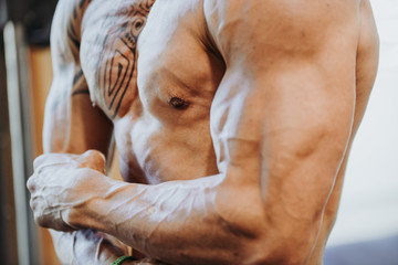 Detail of a muscular man with a tattoo on his chest