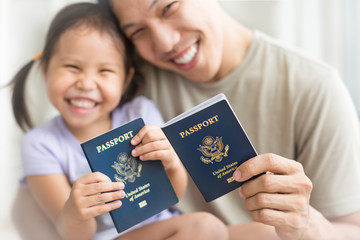Happy immigrant family becoming new American citizens, holding US passports.