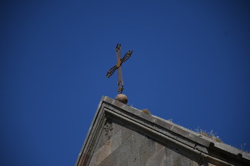 Cross over the Armenian church on the sky background