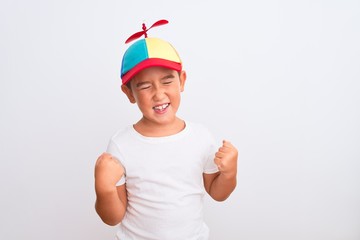 Beautiful kid boy wearing fanny colorful cap with propeller over isolated white background very...