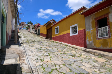 View to steep cobblestone street with colorful houses in historical town São Luíz do Paraitinga, Brazil